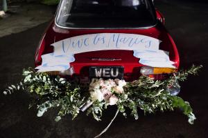 a vintage red car with beautiful wedding flowers 